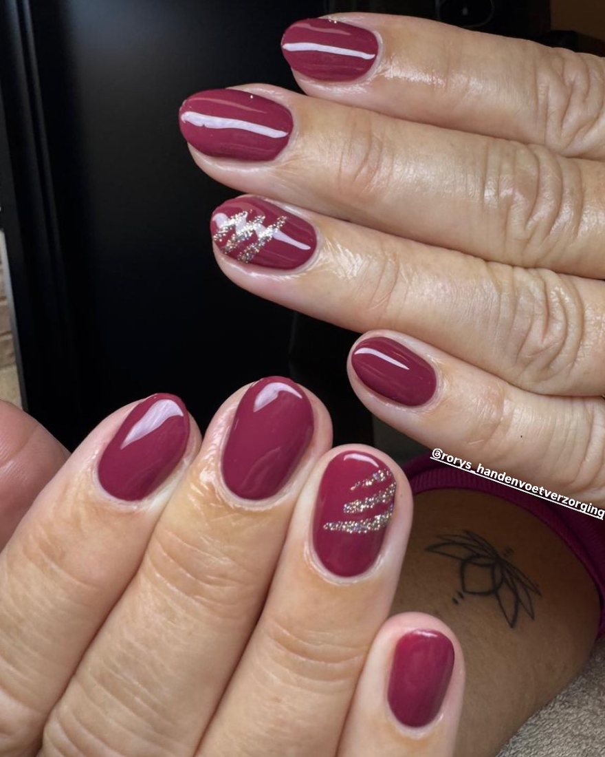 Bordeauxrode nagels met zilveren streepjes op een accentnagel