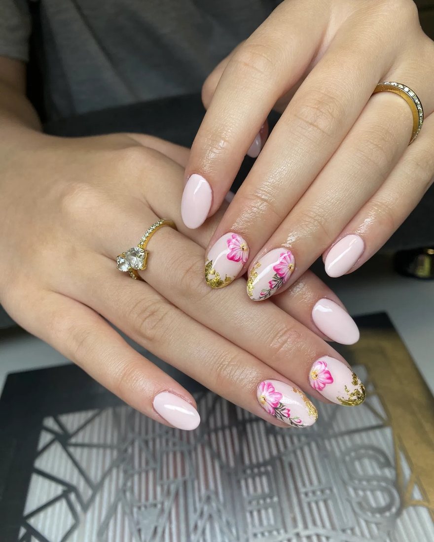 Zachtroze nagels met twee accentnagels vol roze bloemetjes