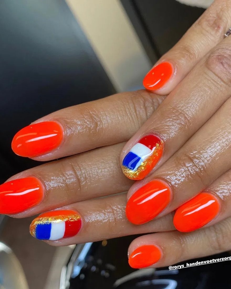 Feloranje nagels met twee accentnagels in rood, wit en blauw